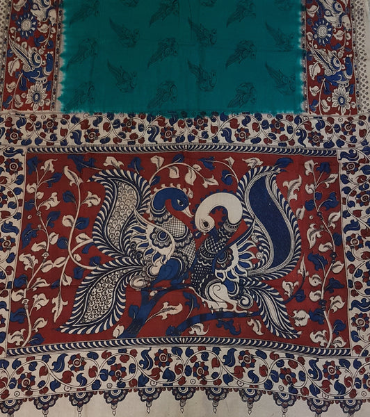 Green mul cotton kalamkari with peacock motif on pallu, border and body of saree.