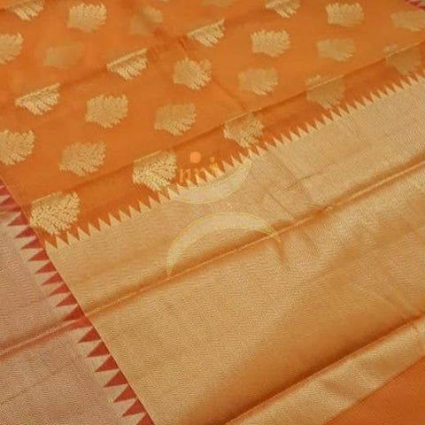 Orange cotton blend benaras brocade with antique zari motif on body, pallu and temple border. The saree comes with blouse piece matching pallu.