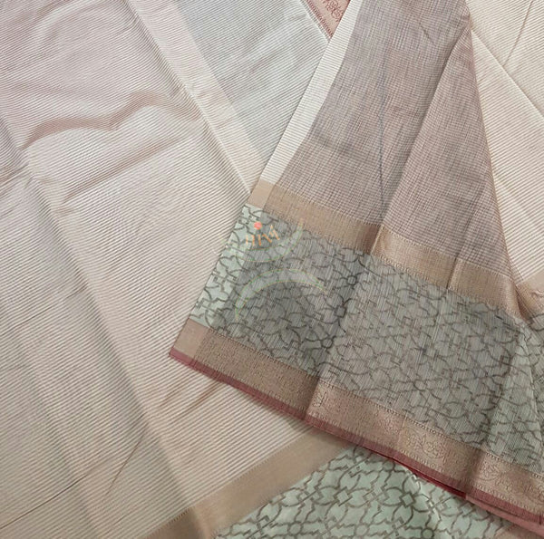 Off white with pink stripes silk cotton saree with woven brocade pallu and border. The saree comes with contrasting striped blouse