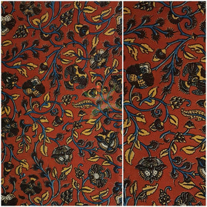 Orange handwoven cotton kalamkari material with floral motifs.