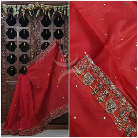 Red supernet saree with kalamkari motif of wedding scene applique on border, mirror work all over body and kalamkari blouse.