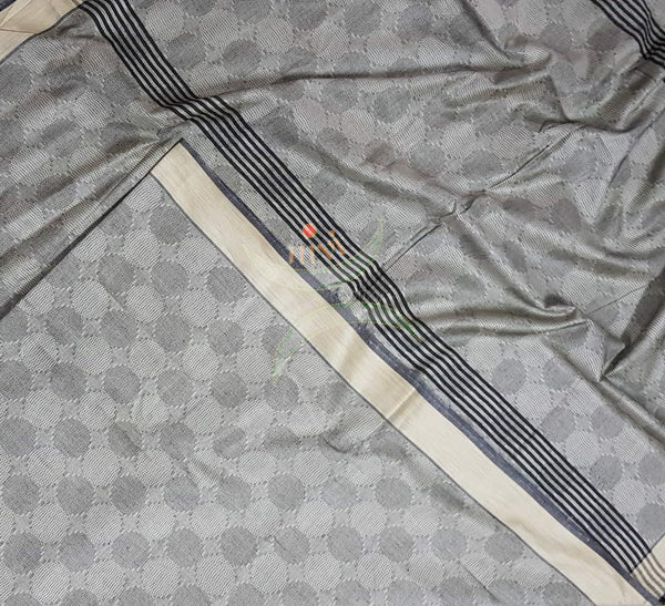 Grey Bengal handloom cotton tussar with all over jacquard weaving. Saree comes with running blouse.