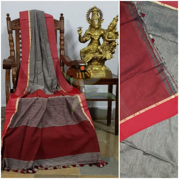 Grey handloom cotton with contrasting brick red border and striped pallu. Saree comes with contrasting brick red blouse piece