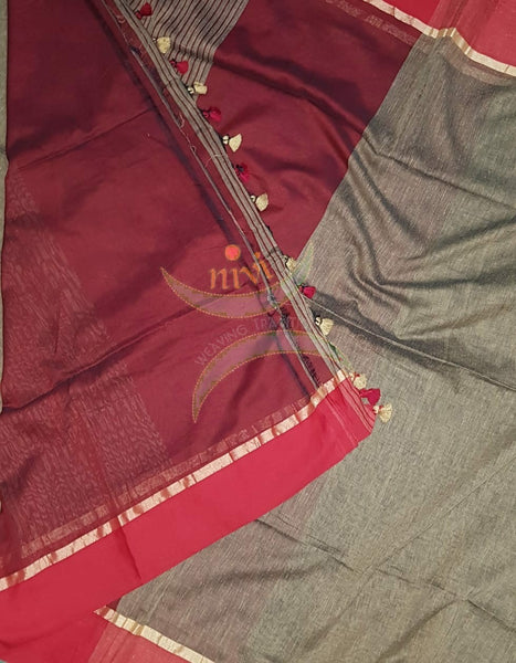 Brown handloom cotton with contrasting maroon shot with pink border and striped pallu. Saree comes with contrasting maroon blouse piece