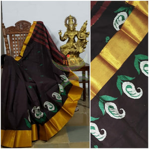 Brown cotton with golden border and paisley cross stitch motif along the border. Saree has striped pallu and comes with running blouse.
