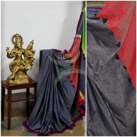 Grey handloom cotton with contrasting purple border, pompoms on multicoloured pallu  and contrasting green blouse.