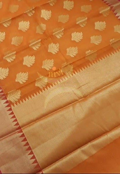 Orange cotton blend benaras brocade with antique zari motif on body, pallu and temple border. The saree comes with blouse piece matching pallu.