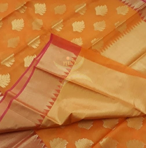 Orange cotton blend benaras brocade with antique zari motif on body, pallu and temple border. The saree comes with blouse piece matching pallu.