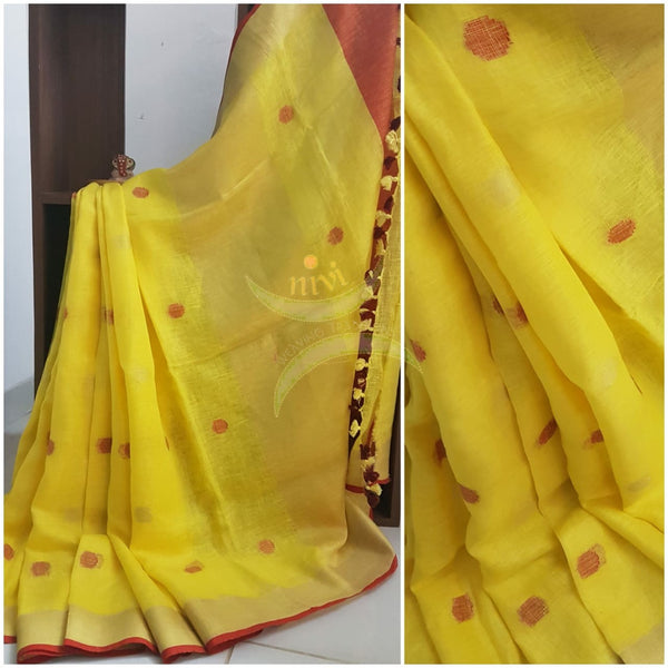 Yellow polka dot handloom linen with pom poms on pallu.