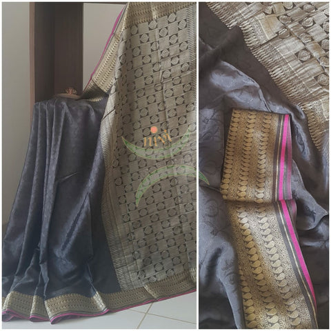 Charcoal grey 70 gms pure silk crepe with self patterned jacquard weave and antique gold pallu and border.
