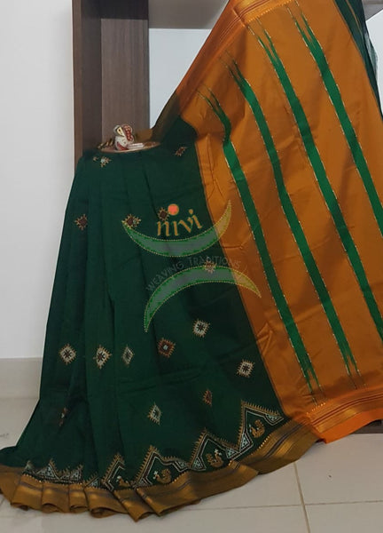 Green silk cotton ilkal with traditional peacock motif kasuti embroidery and mustard tope teni pallu. Saree comes with running blouse.