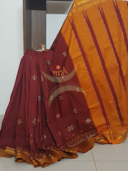 Red silk cotton ilkal with traditional motif kasuti embroidery and mustard tope teni pallu. Saree comes with running blouse.