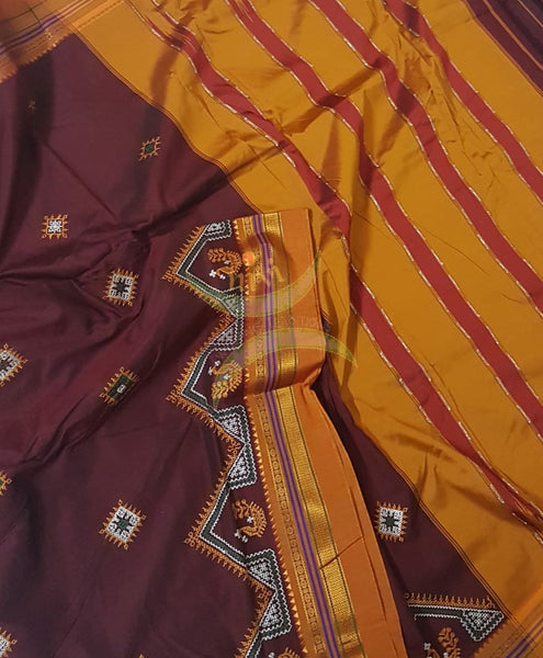 Maroon silk cotton ilkal with traditional peacock motif kasuti embroidery and mustard tope teni pallu. Saree comes with running blouse.
