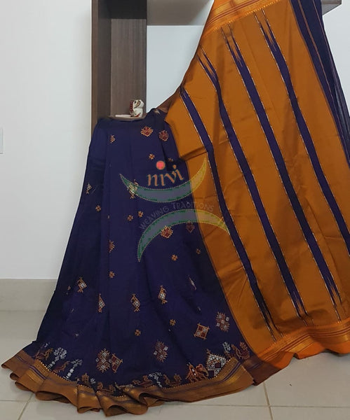 Royal blue silk cotton ilkal with traditional anne ambari gopura motif kasuti embroidery and mustard tope teni pallu. Saree comes with running blouse.