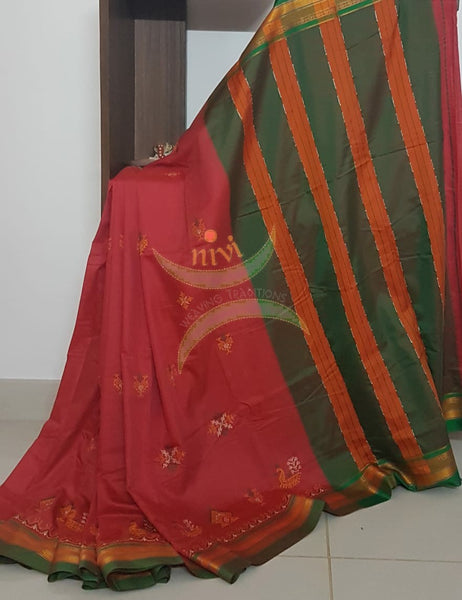 Red cotton blended ilkal with traditional gopura motif kasuti embroidery and green tope teni pallu. Saree comes with running blouse.