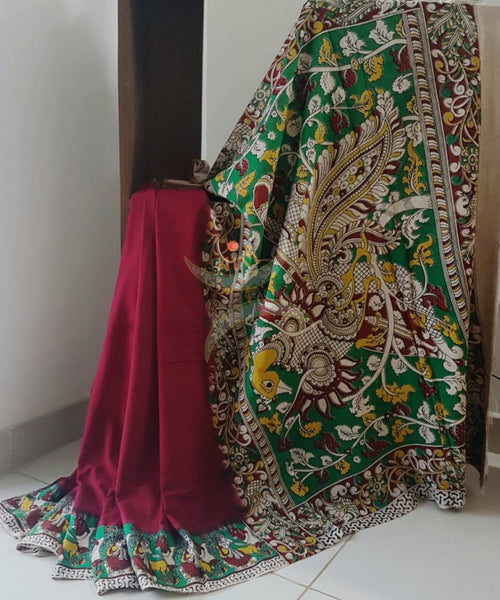 Red mul cotton handloom kalamkari Saree with human figure motifs on border and peacock motif on pallu. Saree comes with kalamkari printed blouse piece.