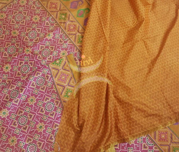 Peachish pink Patola art silk printed saree with contrast blouse piece.