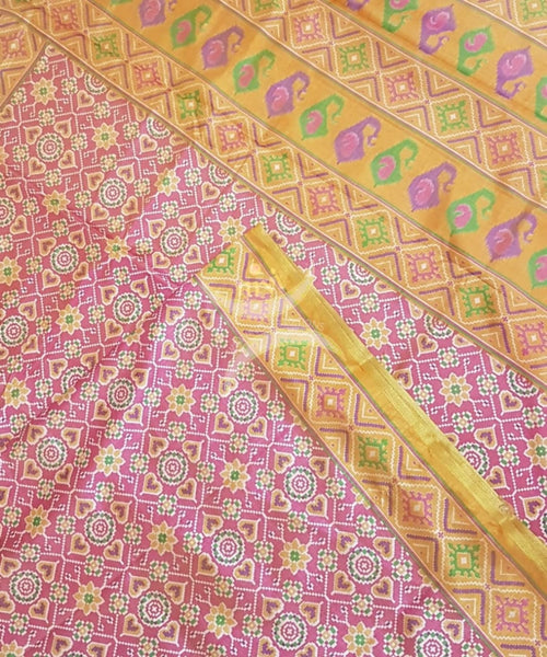 Peachish pink Patola art silk printed saree with contrast blouse piece.