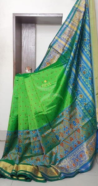 Green Handloom patan patola silk saree with intricate woven pattern and subtle gold zari.