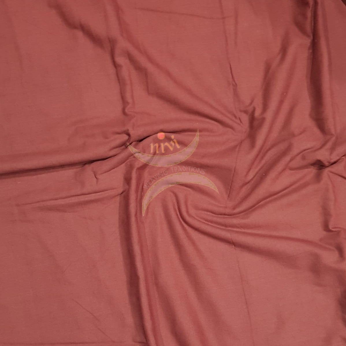 Brick red handloom mercerised cotton fabric.