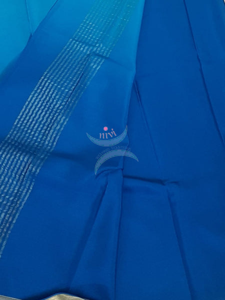 50 gms Two Tone pure Silk Crepe in shades of blue with a fine zari border. Saree comes with pure blue crepe blouse in darker tone.
