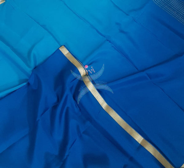 50 gms Two Tone pure Silk Crepe in shades of blue with a fine zari border. Saree comes with pure blue crepe blouse in darker tone.