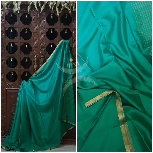 Green 50 gms Two Tone waterproof pure Silk Crepe with a fine zari border. Saree comes with green crepe blouse in darker tone.
