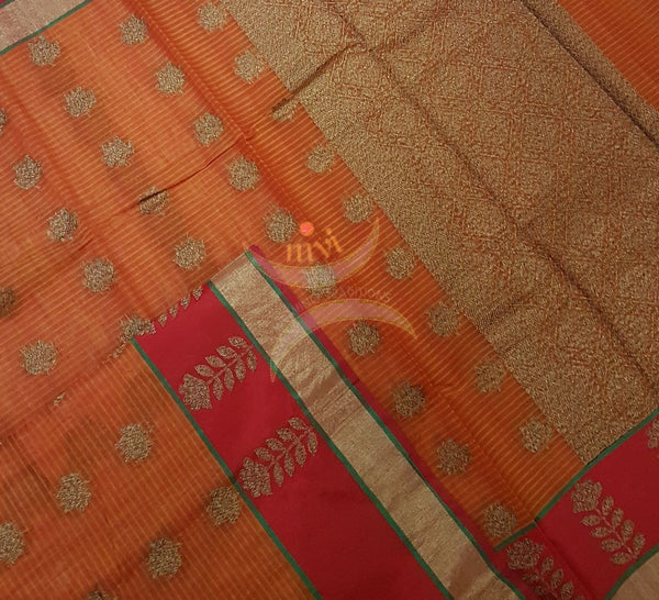 Orange Linen Cotton Benaras Brocade saree with floral motifs, contrast red border and antique zari weaving all over the saree .