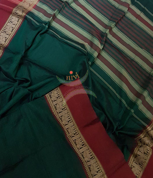 Bottle green with Maroon Eco friendly natural dyed soft organic cotton with mercerised finish. The saree has thread woven traditional border and  striped pallu.