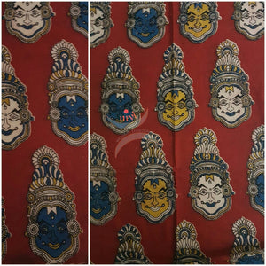Red handwoven cotton kalamkari material with kathakali face motifs.