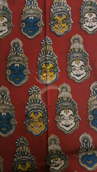 Red handwoven cotton kalamkari material with kathakali face motifs.