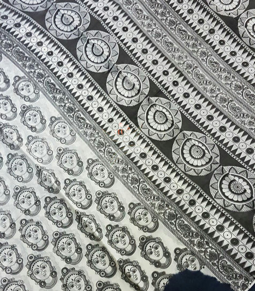 Black and white  mul cotton kalamkari with  kathakali face motifs on the body of the saree.
