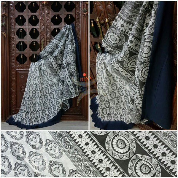 Black and white  mul cotton kalamkari with  kathakali face motifs on the body of the saree.