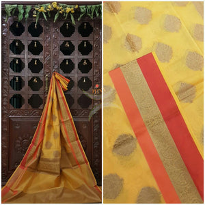 Yellow silk cotton benaras brocade saree with satin finish contrasting border and antique gold zari woven border and pallu and zari booties all over the saree.