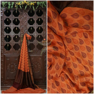 Orange 40 gram Chinon Printed crepe pure silk with contrasting Brown zari border.