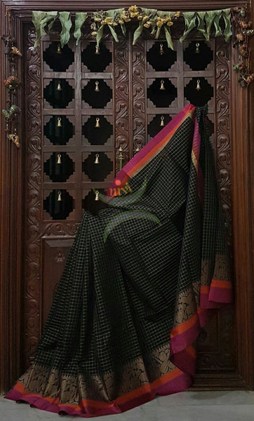 Black Silk Cotton chequered saree with satin finish contrasting pink orange border and woven musical instruments at border with antique gold zari. Saree comes with running blouse.