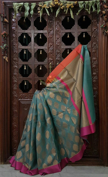 Teal Silk Cotton Benaras Brocade Supernet saree with satin finish contrasting pink orange border and antique woven gold zari all over the saree.
