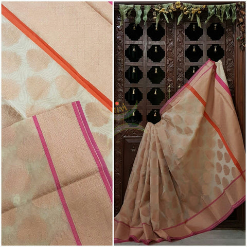 Cream shot Gold Silk Cotton Benaras Brocade Supernet saree with tissue finish contrasting pink orange border and antique woven gold zari all over the saree.