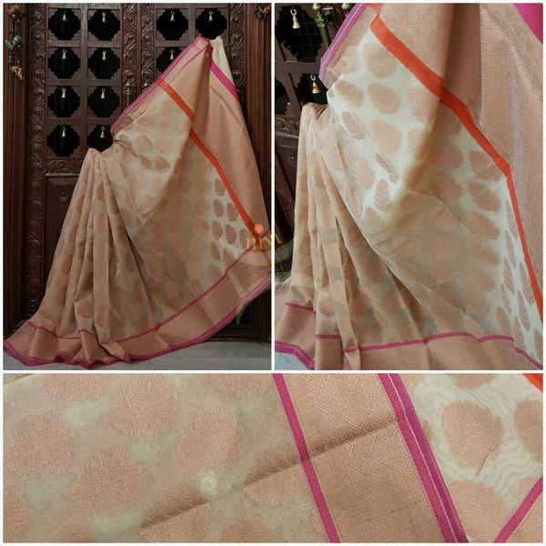 Cream shot Gold Silk Cotton Benaras Brocade Supernet saree with tissue finish contrasting pink orange border and antique woven gold zari all over the saree.