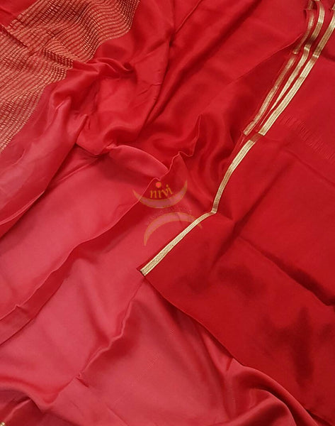 Red 40 gms Two Tone pure Silk Crepe with a fine zari border. Saree comes with pure red crepe blouse in darker tone.