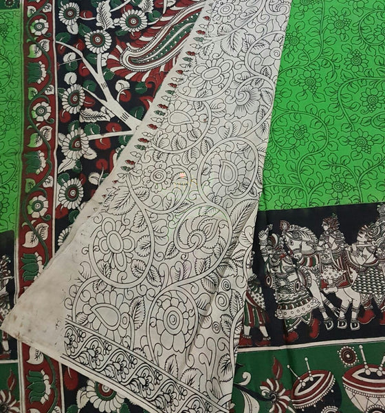 Green mul cotton kalamkari with intricate musical instruments and marriage possession motif on the border and peacock motif on the pallu.