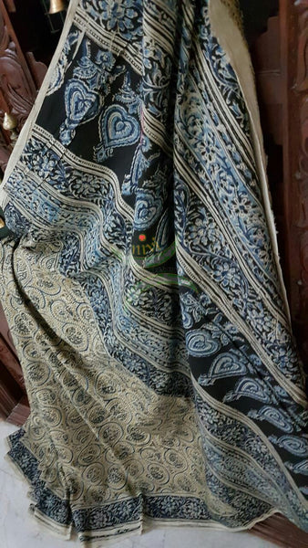 Green mul cotton kalamkari with intricate floral motif on the body, border and pallu of the saree.