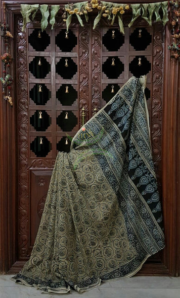 Green mul cotton kalamkari with intricate floral motif on the body, border and pallu of the saree.