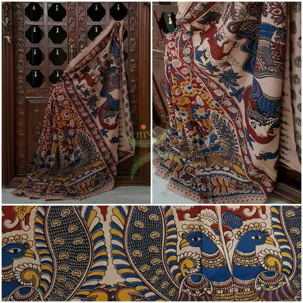 Red mul cotton kalamkari with intricate floral and peacock motif on body of the saree, floral motif on the border and human figure and peacock motif on the pallu.