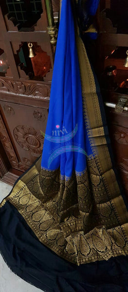 Royal blue with Black Art silk crepe with woven zari border and pallu.