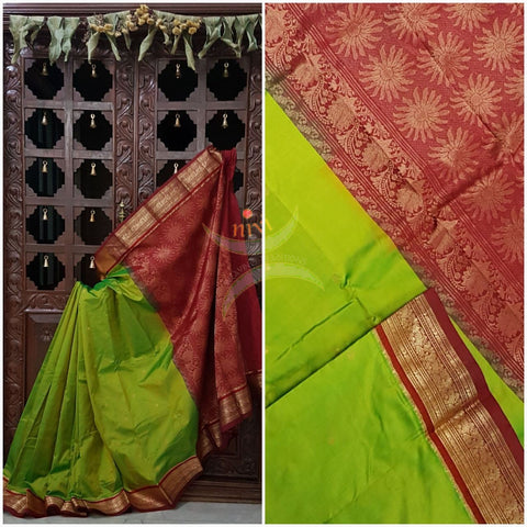Parrot green with red handloom small Ghatti border pure south silk saree woven with floral brocade pattern on pallu, border and has floral booties all over.