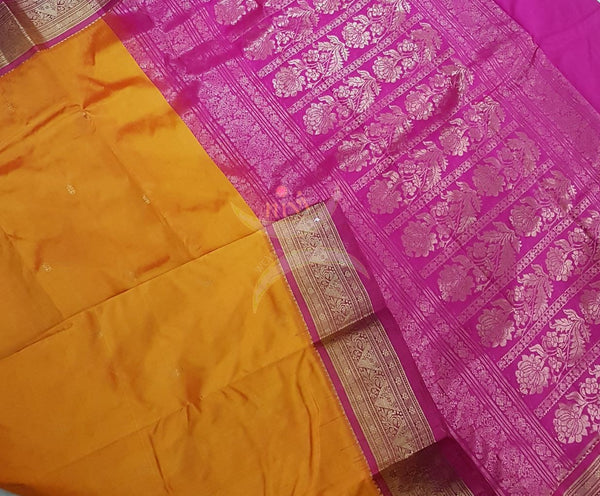 Mustard with pink handloom small Ghatti border pure south silk saree woven with floral brocade pattern on pallu, border and has floral booties all over.