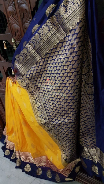 Mustard with double shaded royal blue and pink border pure south silk saree woven with floral brocade pattern on pallu and border. Saree has paisley drop booties all over.