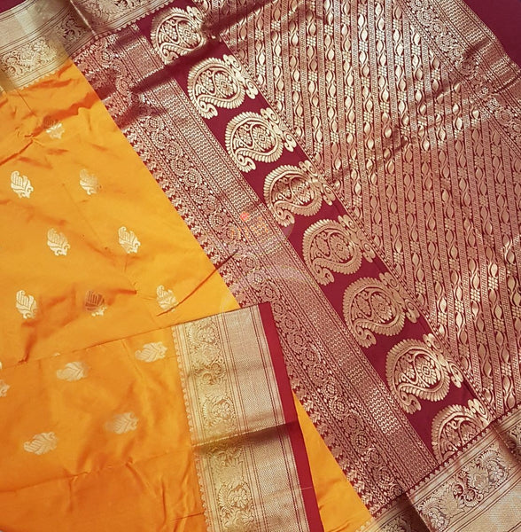 Mustard with maroon pure south silk saree woven with paisley and floral brocade pattern on pallu, border and has paisley and floral booties all over.
