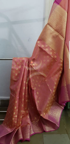 Peach shot pink silk cotton benaras brocade with paisley and floral woven motifs. The saree comes with gold finish blouse piece to match pallu.